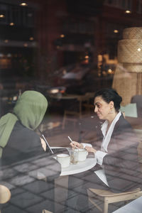 View through window of women in cafe