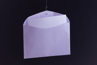 Close-up of paper hanging against black background