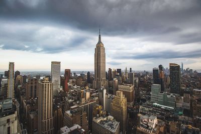 Aerial view of cityscape against cloudy sky