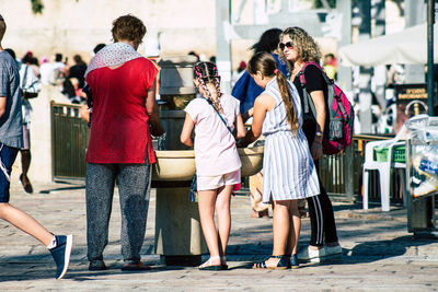 Rear view of people walking on street