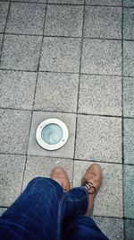 Low section of man standing on tiled floor