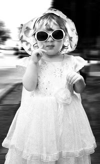 Close-up portrait of girl wearing sunglasses in yard