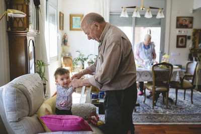 Great-grandfather taking care of a baby girl at home