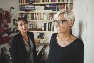 Smiling industrial designers talking to colleague at home office