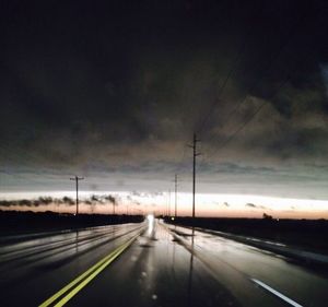 Cars on road against cloudy sky