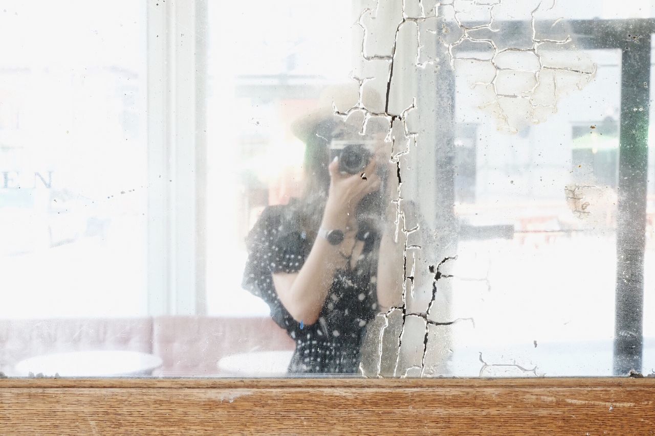 window, one person, glass - material, indoors, real people, day, transparent, lifestyles, women, adult, young adult, motion, domestic room, nature, holding, standing, home, hairstyle