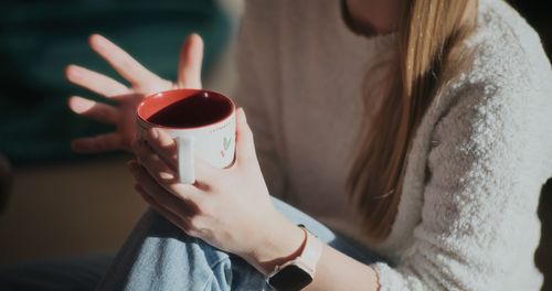 Midsection of woman holding coffee