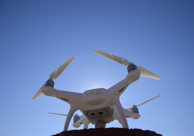 Low angle view of airplane against clear blue sky