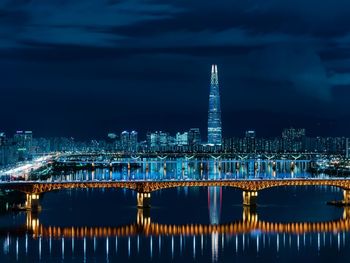 Illuminated bridge over river at night