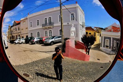 Full length of woman photographing in city