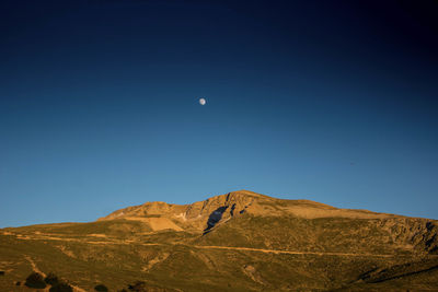 Low angle view of mountains against clear blue sky