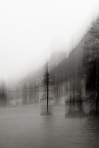 Scenic view of lake against sky during foggy weather