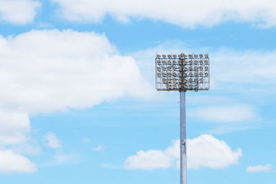 Low angle view of floodlight against cloudy sky