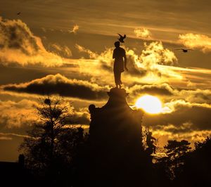 Silhouette of statue at sunset