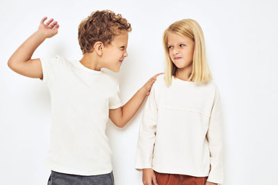 Cute sibling standing against white background