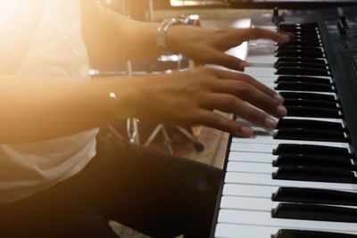 Midsection of pianist playing piano