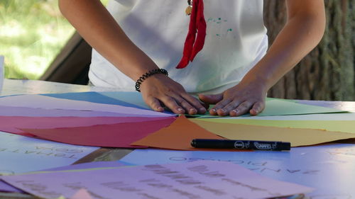 Midsection of man making art from colorful paper