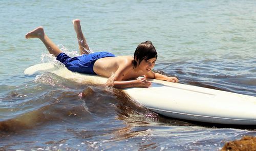 Cute boy on paddleboard in sea