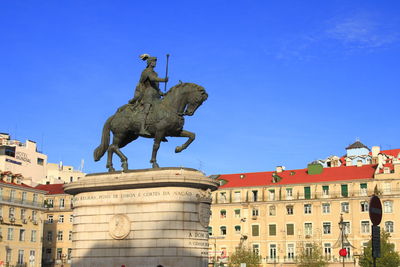 Low angle view of statue against clear blue sky