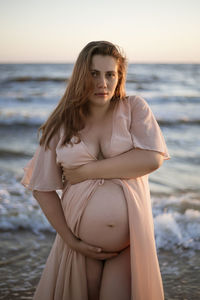 Young pregnant woman with a beautiful sea view on the background. happy and calm pregnant woman 