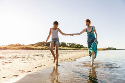 Full length of woman on beach against sky