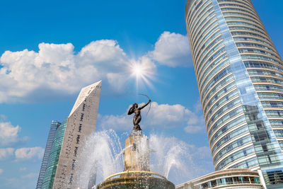 Low angle view of modern building against cloudy sky