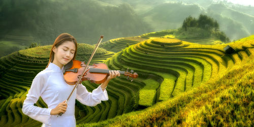 Woman with arms raised on field