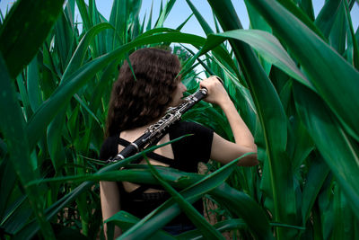 Rear view of woman standing amidst plants