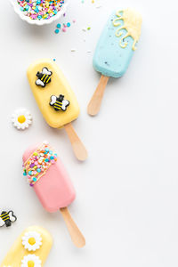 Homemade springtime themed cakesicles with sprinkles and edible decorations.