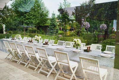 Empty chairs and tables at table in yard