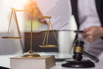 Close-up of hand holding illuminated lighting equipment on table
