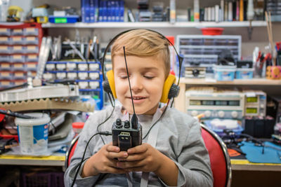 Boy using walkie-talkie in workshop