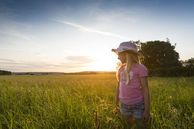 Woman standing on grassy field against sky