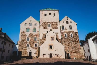 Low angle view of old building against clear blue sky