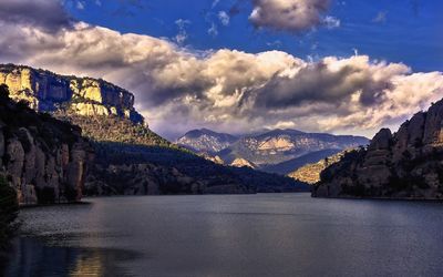 Scenic view of lake by mountains against sky