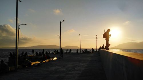 People standing on pier at sea