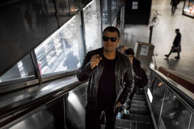 Man standing on escalator at railroad station