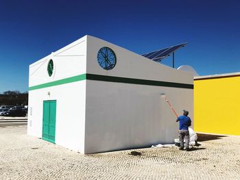 Full length of man standing against clear blue sky