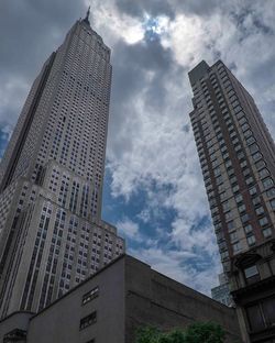 Low angle view of modern building against cloudy sky