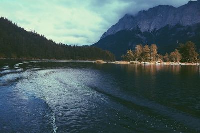 Scenic view of lake by mountains against sky