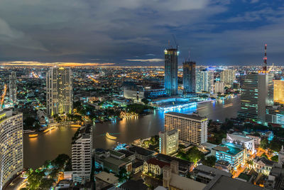 High angle view of illuminated buildings against sky at night