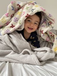 Portrait of cute baby playing on parent bed