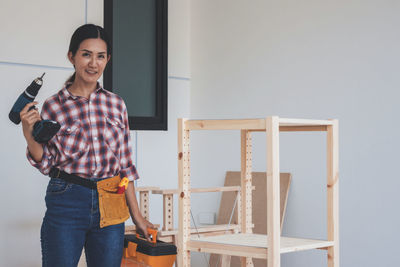 Portrait of smiling woman standing at home