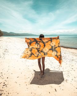 Woman with scarf walking at beach