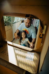 Kuala lumpur, malaysia - august 13, 2021 father and child painting recyled cardboard together.