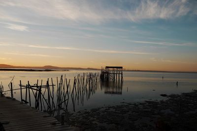 Pier on sea against sky during sunset