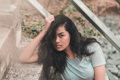 Portrait of young woman sitting outdoors