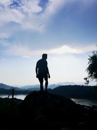 Rear view of silhouette man standing against sky