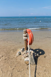 Sunglasses on beach against sky