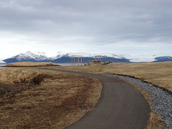 Road leading towards mountains against sky